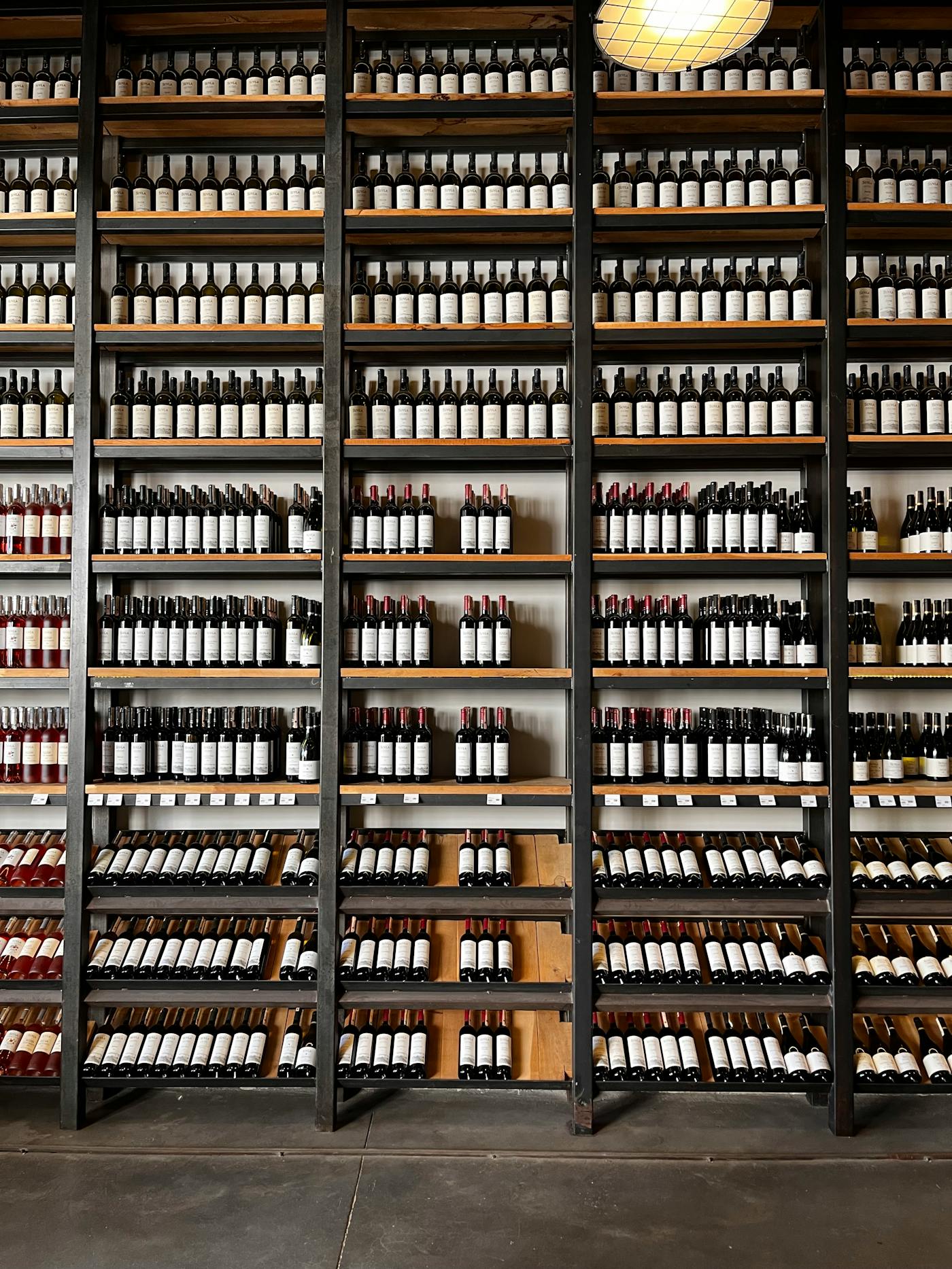 Bouteilles de vin alignées dans une cave - conseil commerce et négoce